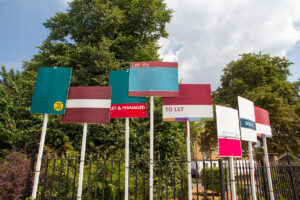 Row of To Let signs outside houses in the UK showing local letting agents